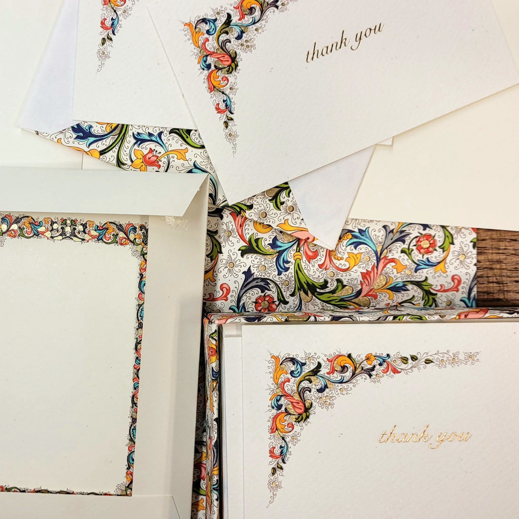 a square image of a spread of cards and envelopes in a colourful italian florentine pattern
